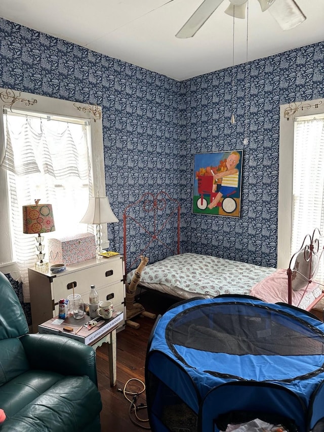 bedroom featuring wood finished floors, ceiling fan, and wallpapered walls