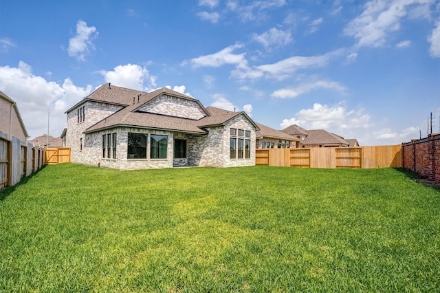 2904 Apple Rose, Katy, TX 77493 - rear view of property featuring stone siding, a lawn, a shingled roof, a fenced backyard, and brick siding
