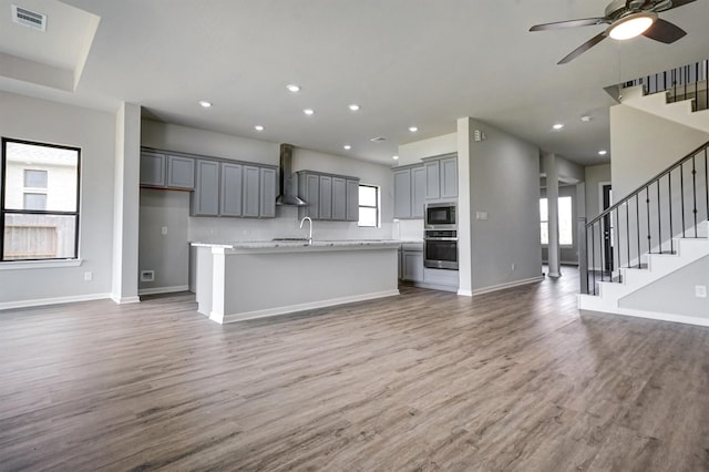 2904 Apple Rose, Katy, TX 77493 - kitchen with built in microwave, stainless steel oven, visible vents, open floor plan, and wall chimney exhaust hood