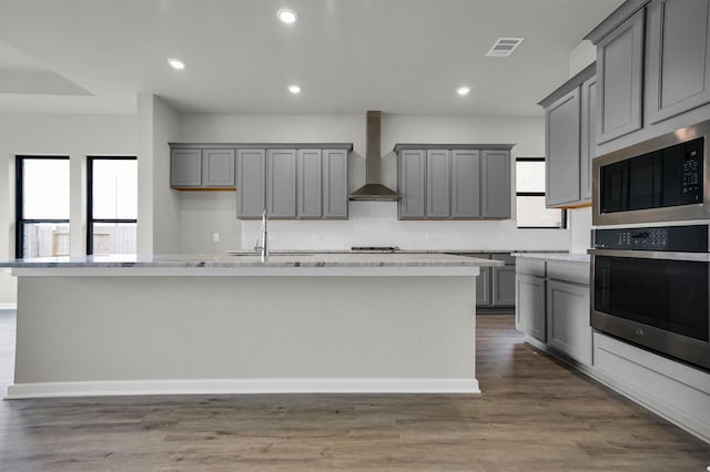 2904 Apple Rose, Katy, TX 77493 - kitchen featuring a sink, decorative backsplash, wall chimney range hood, stainless steel appliances, and gray cabinets
