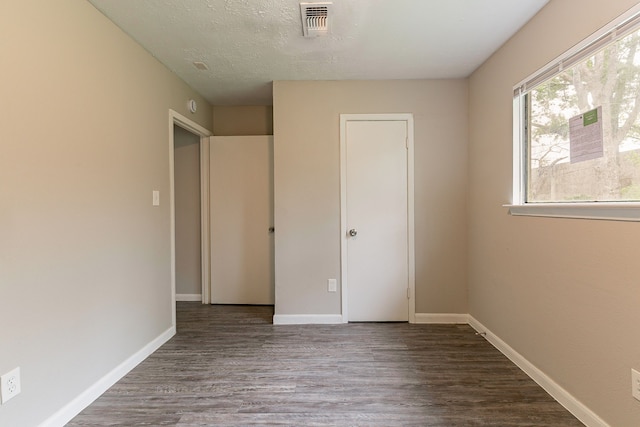 unfurnished bedroom with baseboards, visible vents, and wood finished floors