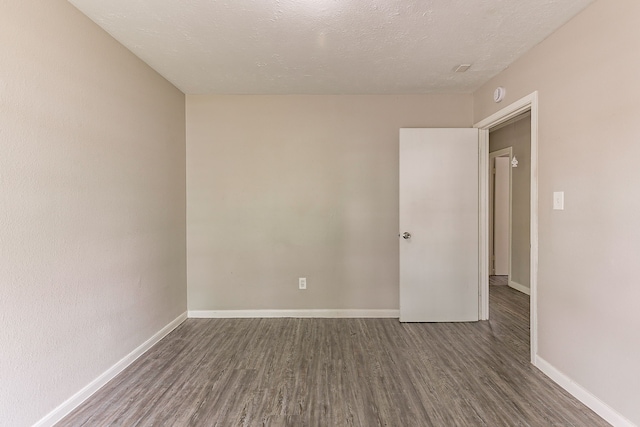 unfurnished room with baseboards and wood finished floors