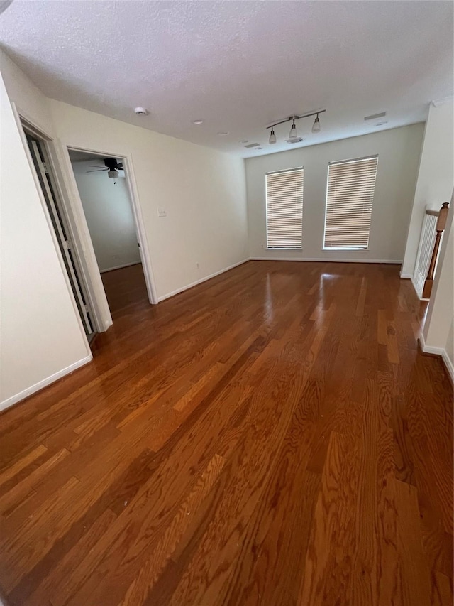 4311 Lakeside Meadow Dr, Missouri City, TX 77459 - spare room with baseboards, a textured ceiling, wood finished floors, and rail lighting