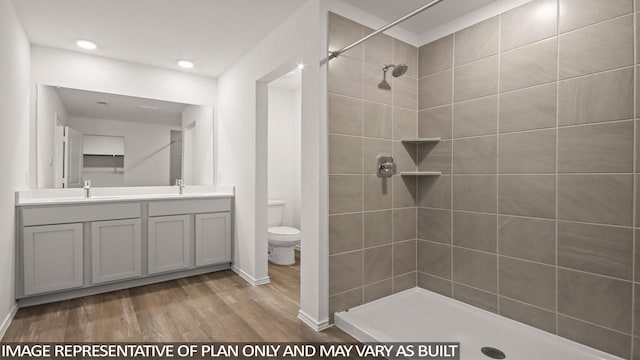 1342 Heather Rosewood Ln, Conroe, TX 77301 - bathroom with toilet, wood finished floors, double vanity, tiled shower, and baseboards