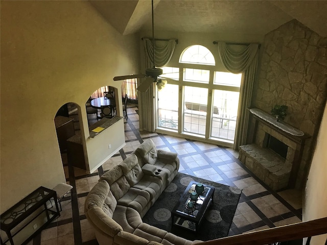 8007 Furleson Dr, Rosenberg, TX 77469 - living area featuring baseboards, ceiling fan, high vaulted ceiling, and a stone fireplace