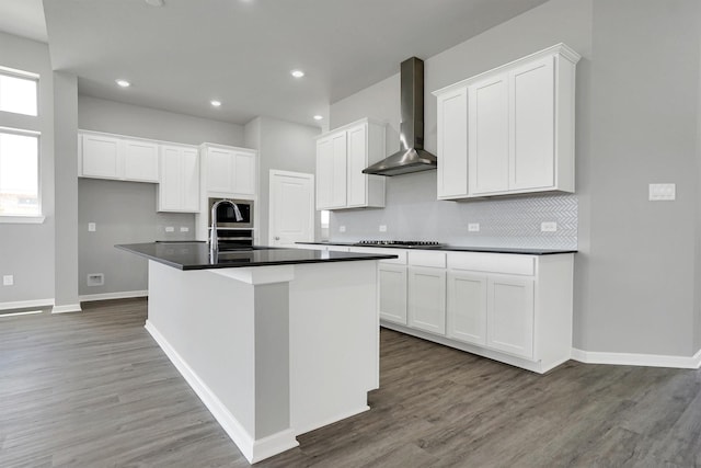 2916 Apple Rose, Katy, TX 77493 - kitchen featuring wall chimney range hood, wood finished floors, cooktop, a sink, and backsplash