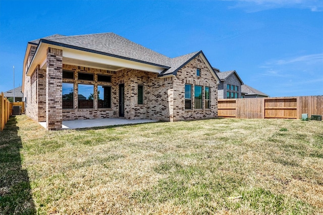 2916 Apple Rose, Katy, TX 77493 - rear view of house featuring a fenced backyard, brick siding, a patio area, a shingled roof, and a yard
