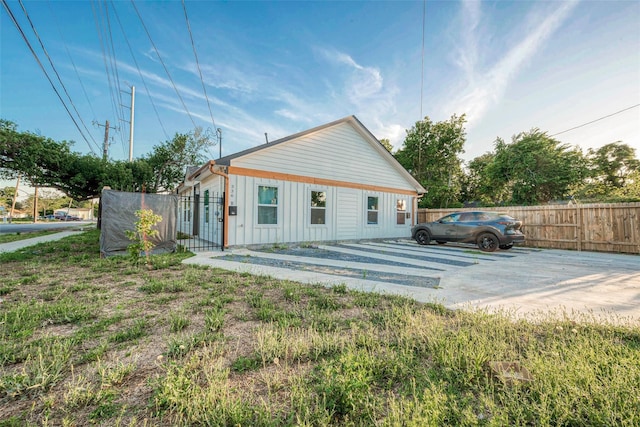 rear view of property with board and batten siding and fence