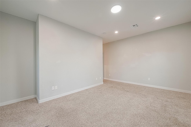 empty room with baseboards, visible vents, recessed lighting, and light colored carpet