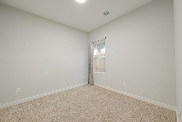unfurnished room featuring baseboards, visible vents, and light colored carpet