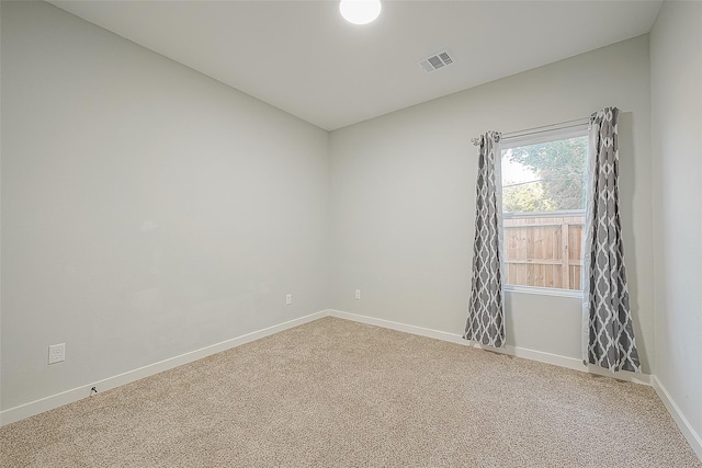 unfurnished room featuring baseboards, visible vents, and carpet
