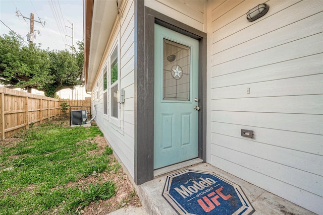 entrance to property featuring fence and cooling unit