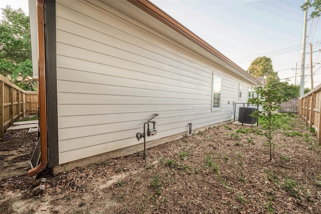 view of side of property featuring central AC unit and a fenced backyard