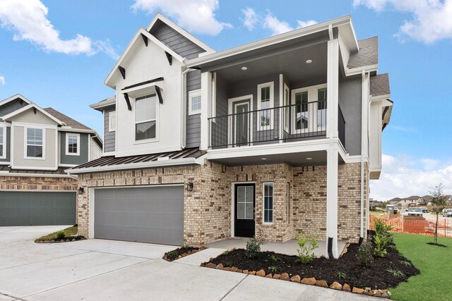 15854 Invergelder Dr, Atascocita, TX 77346 - view of front of home featuring a balcony, an attached garage, brick siding, concrete driveway, and a standing seam roof