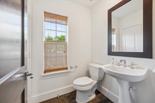 bathroom with baseboards, toilet, and wood finished floors