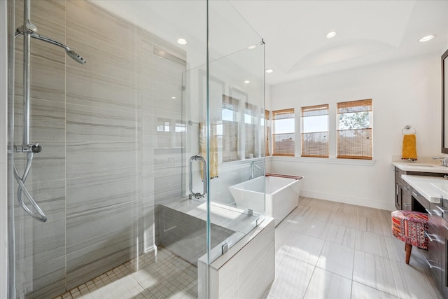full bath featuring a freestanding bath, a shower stall, vanity, a tray ceiling, and recessed lighting