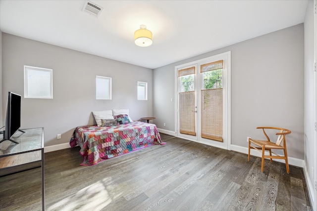 bedroom with baseboards, wood finished floors, and access to exterior