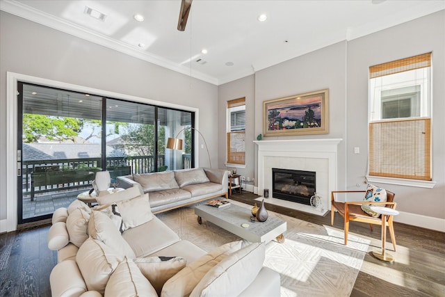 living room featuring visible vents, ornamental molding, a ceiling fan, and a fireplace