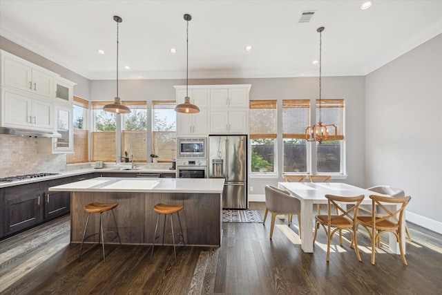 kitchen with visible vents, a kitchen island, a wealth of natural light, and stainless steel appliances