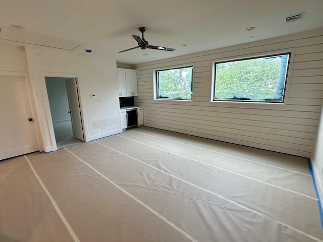 626 E 14th St, Houston, TX 77008 - unfurnished living room with a ceiling fan, concrete floors, and wood walls