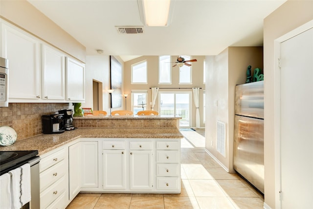 4406 Tampico Way, Galveston, TX 77554 - kitchen featuring white cabinetry, a peninsula, stainless steel appliances, visible vents, and decorative backsplash