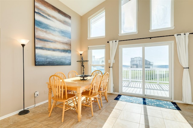 4406 Tampico Way, Galveston, TX 77554 - dining room with light tile patterned flooring, baseboards, and a towering ceiling