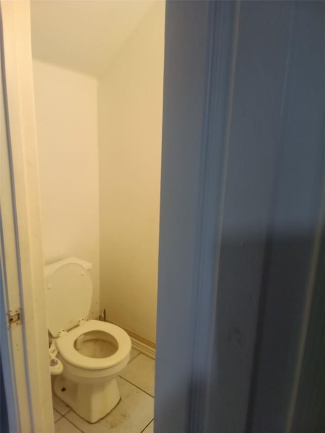 bathroom featuring baseboards, toilet, and tile patterned floors