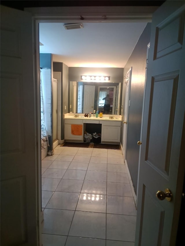 bathroom featuring vanity, baseboards, a shower with shower curtain, tile patterned floors, and visible vents