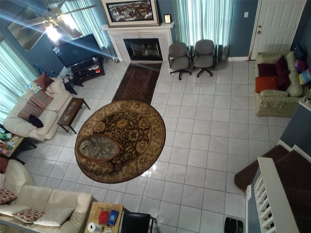 living room with a ceiling fan, tile patterned flooring, and a fireplace