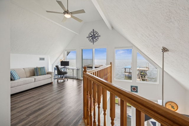 living area with a textured ceiling, a ceiling fan, wood finished floors, beamed ceiling, and visible vents