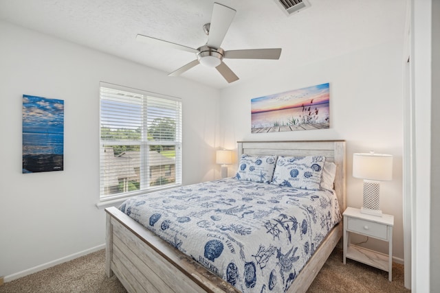 carpeted bedroom with visible vents, a ceiling fan, and baseboards