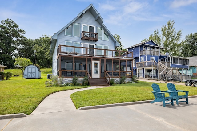 view of front of property featuring a porch, an outdoor structure, a balcony, a front lawn, and a storage unit