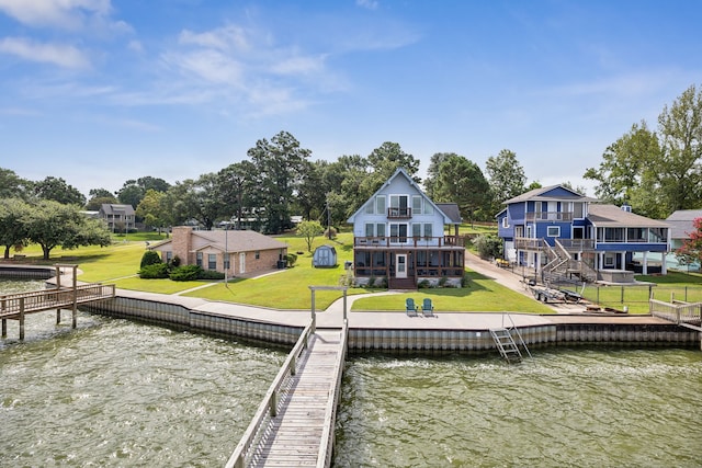dock area with a water view, a yard, and a balcony