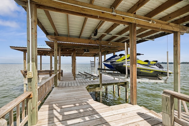 dock area featuring boat lift and a water view