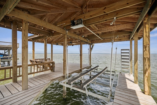dock area with boat lift and a water view