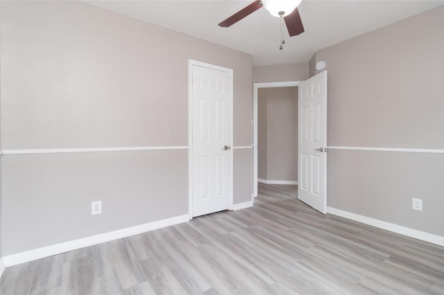 empty room with baseboards, wood finished floors, and ceiling fan