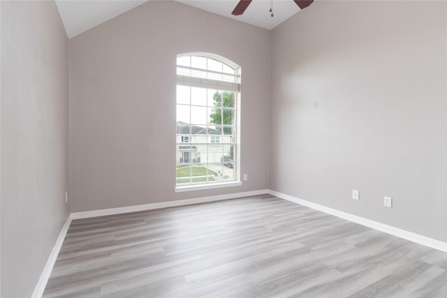 empty room featuring baseboards, lofted ceiling, ceiling fan, and light wood-style floors