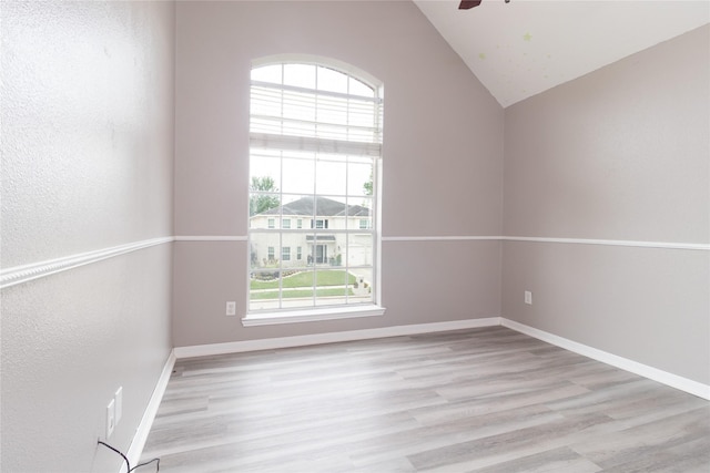 spare room with a ceiling fan, baseboards, lofted ceiling, and wood finished floors