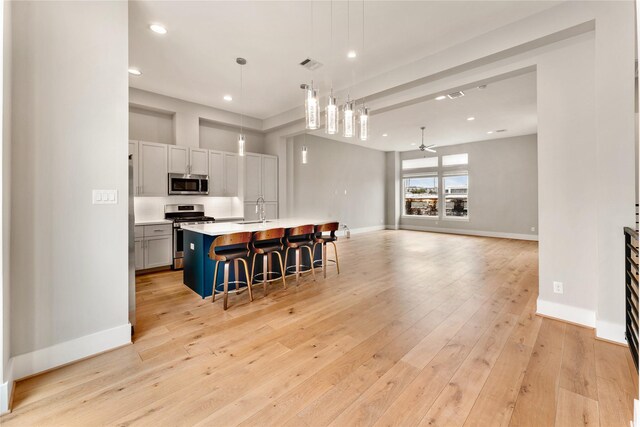 1033 Roberts St, Houston, TX 77003 - kitchen with appliances with stainless steel finishes, a sink, a kitchen breakfast bar, light countertops, and baseboards