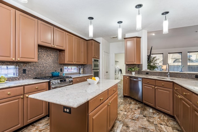 kitchen with backsplash, a sink, light stone countertops, stainless steel appliances, and independent washer and dryer