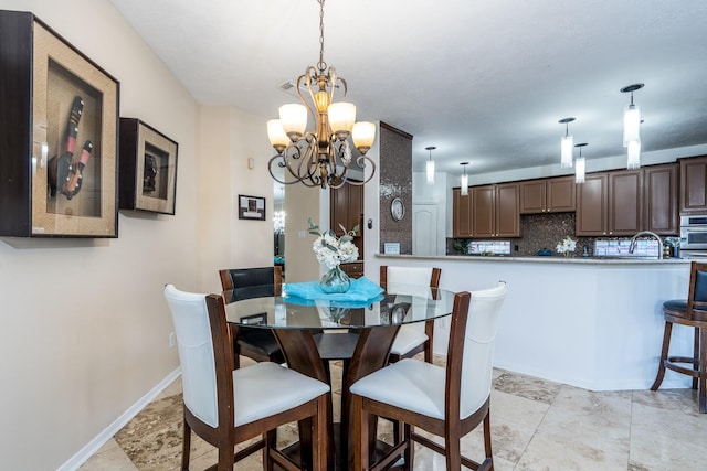 dining space featuring baseboards and a chandelier