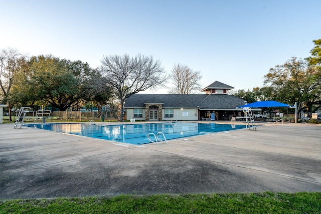 community pool featuring fence and a patio