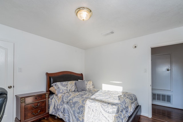 bedroom with dark wood-style flooring and visible vents