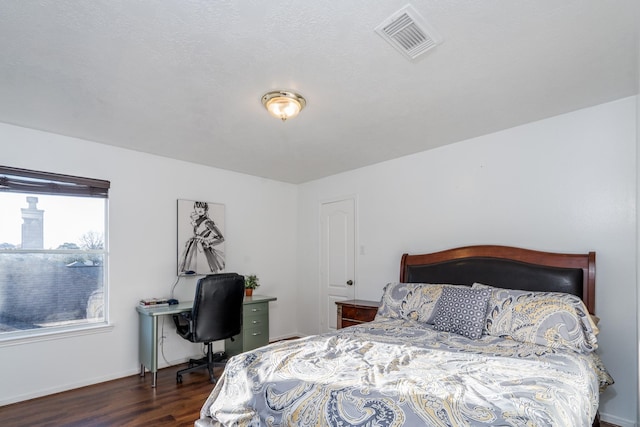 bedroom featuring baseboards, visible vents, and wood finished floors
