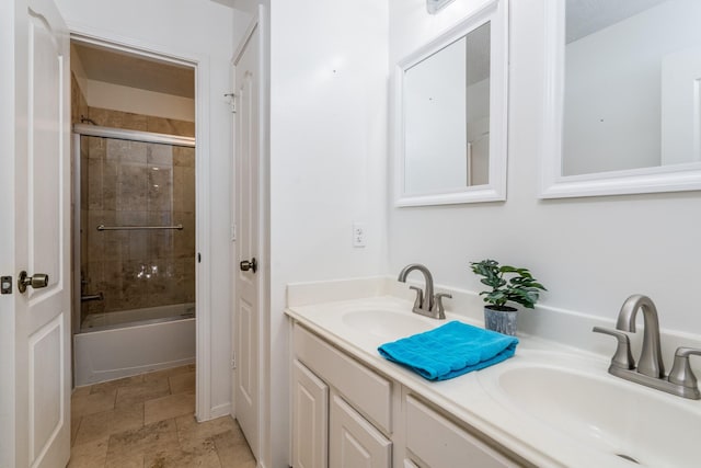 full bathroom featuring double vanity, a sink, enclosed tub / shower combo, and stone tile floors