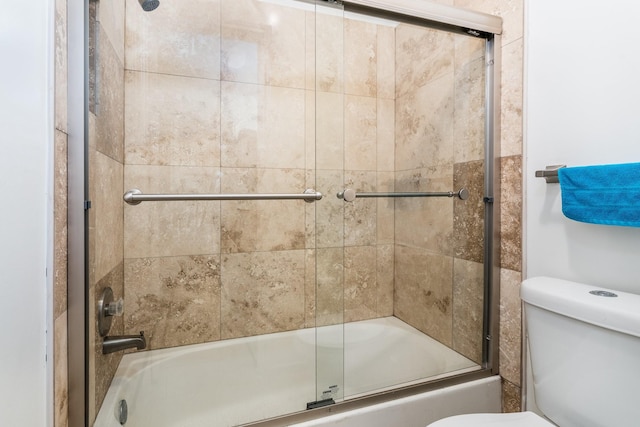 full bathroom featuring toilet and combined bath / shower with glass door