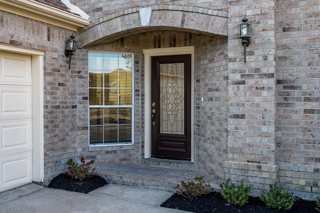 doorway to property featuring brick siding
