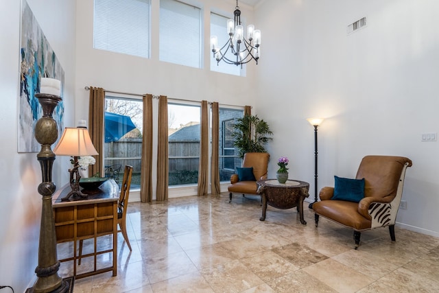 sitting room featuring a towering ceiling, baseboards, a chandelier, and visible vents