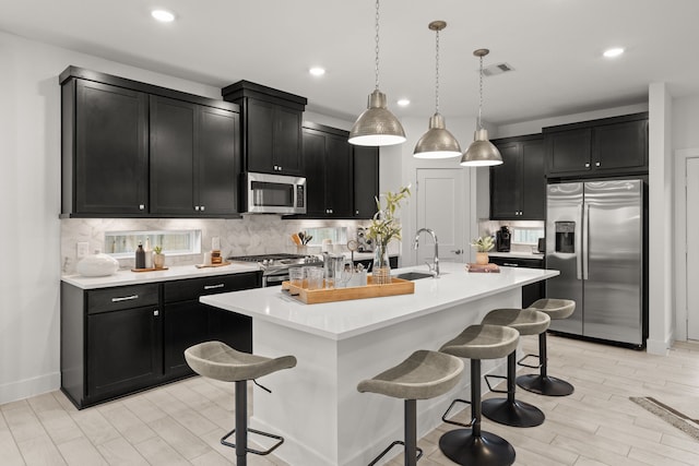 kitchen with dark cabinets, appliances with stainless steel finishes, and a sink