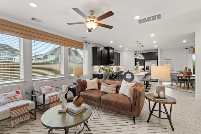 living area with recessed lighting, light wood finished floors, visible vents, and ceiling fan